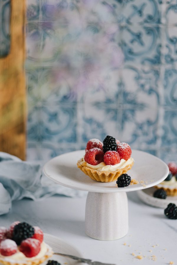 culinary styling of a crisp cupcake with fruit on a tiled background